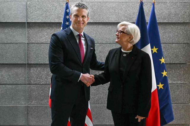 French Minister of the Armed Forces and Veterans Catherine Vautrin (R) welcomes US Secretary of War Pete Hegseth ahead of a ceremony marking the 82nd anniversary of the D-Day landings at the Normandy American Cemetery in Colleville-sur-Mer, northwestern France, on June 6, 2026. (Photo by LOU BENOIST / AFP) / QUALITY REPEAT
