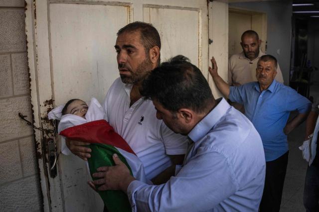 EDITORS NOTE: Graphic content / Family members carry the body of seven-month-old Sam Fahd Abou Haikal, at the Al-Ahli hospital in Hebron, in the occupied West Bank on June 6, 2026. The Palestinian health ministry said Israeli gunfire killed an infant and wounded his parents on June 5 in the occupied West Bank. Sam Fahd Abou Haikal, aged seven months, died and his parents were lightly injured "after the occupation forces opened fire on them on June 5 evening" in the south of the city of Hebron, the ministry said. (Photo by JOHN WESSELS / AFP)
