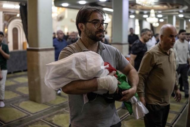 EDITORS NOTE: Graphic content / Palestinian Fahd Abou Haikal carries the body of his seven-month-old baby Sam Fahd Abou Haikal, at the Abou Heisheh Mosque in Hebron, in the occupied West Bank on June 6, 2026. The Palestinian health ministry said Israeli gunfire killed an infant and wounded his parents on June 5 in the occupied West Bank. Sam Fahd Abou Haikal died and his parents were lightly injured "after the occupation forces opened fire on them on June 5 evening" in the south of the city of Hebron, the ministry said. (Photo by JOHN WESSELS / AFP)