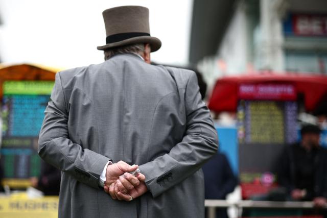 A punter eyes the bookmaker's board prices ahead of racing on the second day of the Epsom Derby Festival horse racing event in Surrey, southern England on June 6, 2026. (Photo by Henry Nicholls / AFP)