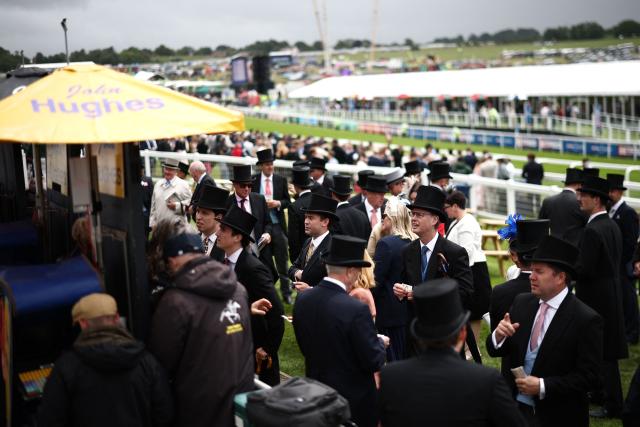 Racegoers place bets with bookmakers ahead of racing on the second day of the Epsom Derby Festival horse racing event in Surrey, southern England on June 6, 2026. (Photo by Henry Nicholls / AFP)