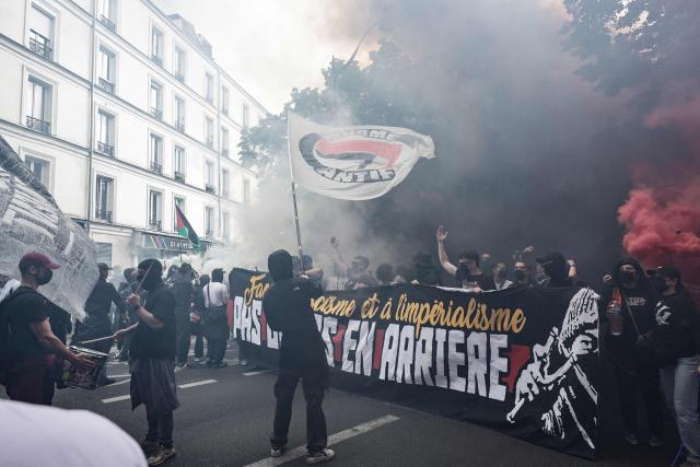 Demonstrators hold flags and banners and burn flares as they take part of a march to mark the 13th anniversary of the death in 2013 of anti-fascist militant Clement Meric, who died after a brawl with skinheads, in Paris on June 6, 2026. (Photo by STEPHANE DE SAKUTIN / AFP)