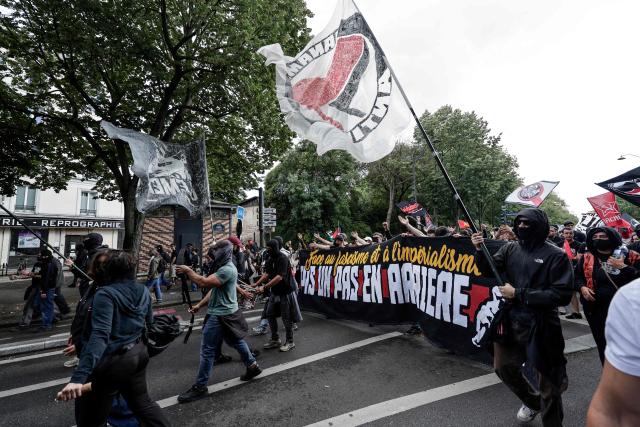 Demonstrators hold flags and banners  as they take part of a march to mark the 13th anniversary of the death in 2013 of anti-fascist militant Clement Meric, who died after a brawl with skinheads, in Paris on June 6, 2026. (Photo by STEPHANE DE SAKUTIN / AFP)