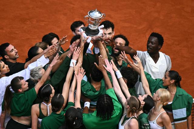 Dancers lift the Coupe Suzanne Lenglen (Suzanne Lenglen Trophy) as they perform during the ceremony prior the women's final singles match on day 14 of the French Open tennis tournament on Court Philippe-Chatrier at the Roland-Garros Complex in Paris on June 6, 2026. (Photo by JULIEN DE ROSA / AFP)