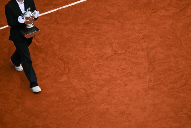 An official brings the Coupe Suzanne Lenglen (Suzanne Lenglen Trophy) during the ceremony prior to the women's final singles match on day 14 of the French Open tennis tournament on Court Philippe-Chatrier at the Roland-Garros Complex in Paris on June 6, 2026. (Photo by JULIEN DE ROSA / AFP)