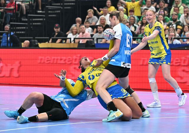 Metz's French pivot #27 Sarah Bouktit (2L) is tackled by CSM Bucuresti's Montenegrin left back Djurdjina Jaukovic (L) and CSM Bucuresti's Russian right back Valeriia Maslova during the EHF Women's Handball Champions League semi-final match between Metz Handball and CSM Bucuresti in Budapest on June 6, 2026. (Photo by Attila KISBENEDEK / AFP)