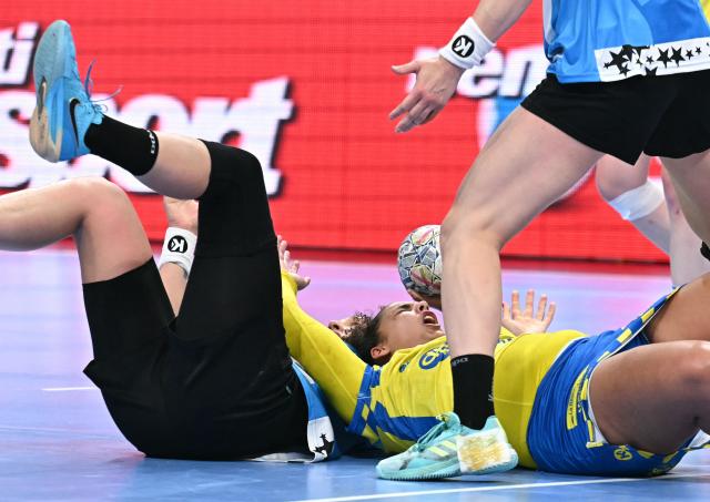 Metz's French pivot #27 Sarah Bouktit (C) is tackled by CSM Bucuresti's Montenegrin left back Djurdjina Jaukovic (L) and CSM Bucuresti's Russian right back Valeriia Maslova during the EHF Women's Handball Champions League semi-final match between Metz Handball and CSM Bucuresti in Budapest on June 6, 2026. (Photo by Attila KISBENEDEK / AFP)