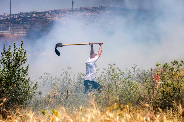 A man attempts to extinguish a fire in a field in the Palestinian town of Huwara in the occupied West Bank on June 6, 2026, after a reported arson attack by Israeli settlers according to local officials. Shielded by what Palestinians and rights group describe as complete impunity from the law, some Israeli settlers have harassed rural Palestinian communities, vandalising property, committing arson, sometimes killing. Excluding east Jerusalem, more than 500,000 Israelis live in the occupied West Bank in settlements that are illegal under international law, among some three million Palestinians. Israel has occupied the West Bank since 1967. (Photo by Jaafar ASHTIYEH / AFP)