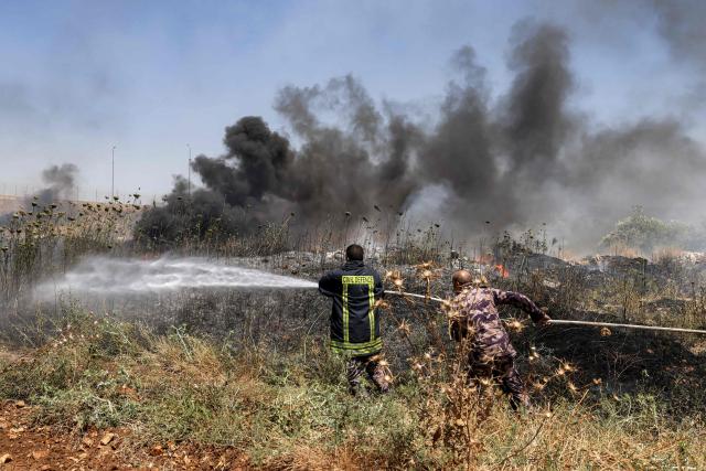 Civil defence forces and volunteers attempt to extinguish a fire in a field in the Palestinian town of Huwara in the occupied West Bank on June 6, 2026, after a reported arson attack by Israeli settlers according to local officials. Shielded by what Palestinians and rights group describe as complete impunity from the law, some Israeli settlers have harassed rural Palestinian communities, vandalising property, committing arson, sometimes killing. Excluding east Jerusalem, more than 500,000 Israelis live in the occupied West Bank in settlements that are illegal under international law, among some three million Palestinians. Israel has occupied the West Bank since 1967. (Photo by JAAFAR ASHTIYEH / AFP)