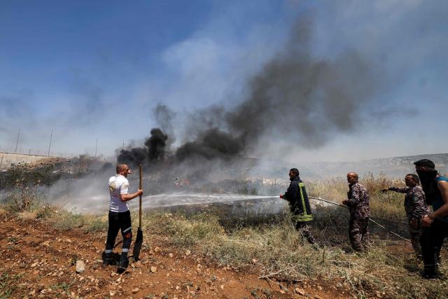 Civil defence forces and volunteers attempt to extinguish a fire in a field in the Palestinian town of Huwara in the occupied West Bank on June 6, 2026, after a reported arson attack by Israeli settlers according to local officials. Shielded by what Palestinians and rights group describe as complete impunity from the law, some Israeli settlers have harassed rural Palestinian communities, vandalising property, committing arson, sometimes killing. Excluding east Jerusalem, more than 500,000 Israelis live in the occupied West Bank in settlements that are illegal under international law, among some three million Palestinians. Israel has occupied the West Bank since 1967. (Photo by JAAFAR ASHTIYEH / AFP)