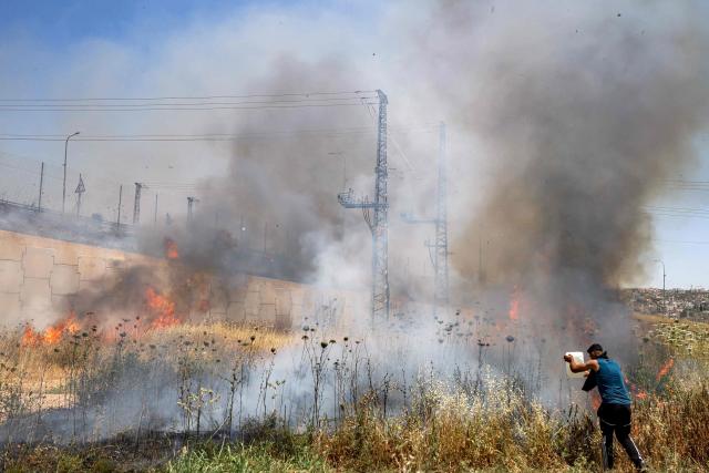 A man attempts to extinguish a fire in a field in the Palestinian town of Huwara in the occupied West Bank on June 6, 2026, after a reported arson attack by Israeli settlers according to local officials. Shielded by what Palestinians and rights group describe as complete impunity from the law, some Israeli settlers have harassed rural Palestinian communities, vandalising property, committing arson, sometimes killing. Excluding east Jerusalem, more than 500,000 Israelis live in the occupied West Bank in settlements that are illegal under international law, among some three million Palestinians. Israel has occupied the West Bank since 1967. (Photo by JAAFAR ASHTIYEH / AFP)