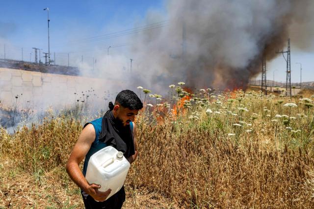 A man attempts to extinguish a fire in a field in the Palestinian town of Huwara in the occupied West Bank on June 6, 2026, after a reported arson attack by Israeli settlers according to local officials. Shielded by what Palestinians and rights group describe as complete impunity from the law, some Israeli settlers have harassed rural Palestinian communities, vandalising property, committing arson, sometimes killing. Excluding east Jerusalem, more than 500,000 Israelis live in the occupied West Bank in settlements that are illegal under international law, among some three million Palestinians. Israel has occupied the West Bank since 1967. (Photo by JAAFAR ASHTIYEH / AFP)