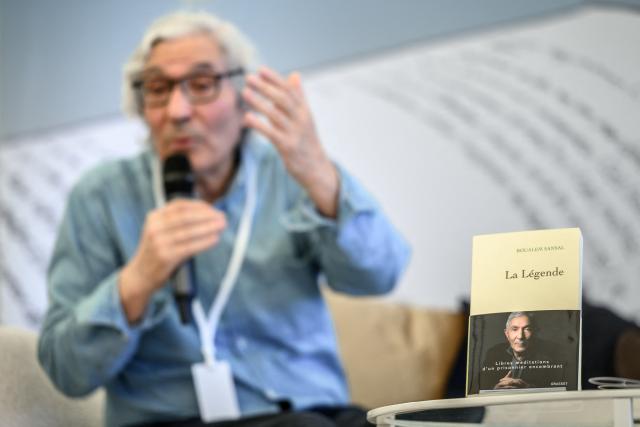 This photograph shows "La Legende", a book by Franco-Algerian writer Boualem Sansal as he speaks during a conversation at the Festival du Livre a Collonge - LAC (Books at Collonge) literary festival, after publishing "La Legende", recounting his detention in Algeria, in Collonge-Bellerive, near Geneva on June 6, 2026. The release has already sparked extensive debate, placing the author at the centre of diplomatic, intellectual and political controversies. (Photo by Fabrice COFFRINI / AFP)