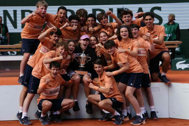 Russia's Mirra Andreeva poses with ball girls and ball boys after winning the French Open tennis tournament women's singles final match against Poland's Maja Chwalinska on day 14 of the French Open tennis tournament on Court Philippe-Chatrier at the Roland-Garros Complex in Paris on June 6, 2026. (Photo by Dimitar DILKOFF / AFP)