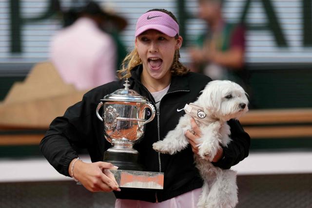 Russia's Mirra Andreeva poses with the Coupe Suzanne Lenglen (Suzanne Lenglen Trophy) and her dog after winning the French Open tennis tournament women's singles final match against Poland's Maja Chwalinska on day 14 of the French Open tennis tournament on Court Philippe-Chatrier at the Roland-Garros Complex in Paris on June 6, 2026. (Photo by Dimitar DILKOFF / AFP)