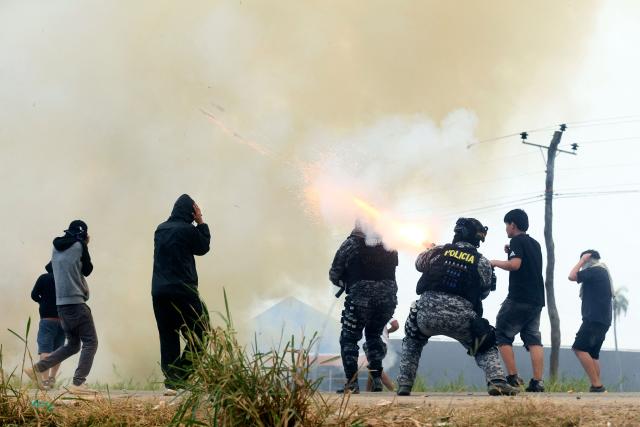 Police officers and civilians clash with anti-government demonstrators during an operation to clear a road blockade in San Julian, Santa Cruz department, Bolivia, on June 6, 2026. Bolivia has faced days of demonstrations and road blockades amid growing political tensions and shortages affecting different regions of the country. (Photo by Rodrigo URZAGASTI / AFP)