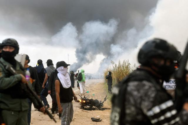 Police officers and civilians clash with anti-government demonstrators during an operation to clear a road blockade in San Julian, Santa Cruz department, Bolivia, on June 6, 2026. Bolivia has faced days of demonstrations and road blockades amid growing political tensions and shortages affecting different regions of the country. (Photo by Rodrigo URZAGASTI / AFP)