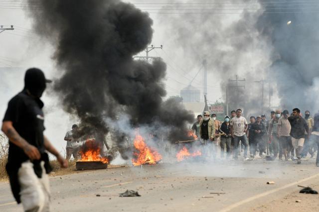 Anti-government demonstrators clash with police officers and civilians during an operation to clear a road blockade in San Julian, Santa Cruz department, Bolivia, on June 6, 2026. Bolivia has faced days of demonstrations and road blockades amid growing political tensions and shortages affecting different regions of the country. (Photo by Rodrigo URZAGASTI / AFP)