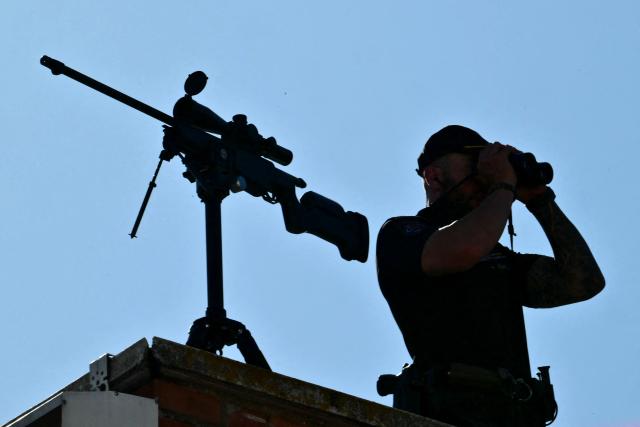 A sniper watches from a roof top during Pope Leo XIV's visit to Caritas charity's centre for homeless people “Cedia 24 horas” in Lucero neighbourhood in Madrid, on June 6, 2026. Pope Leo XIV is visiting Spain June 6-12 with stops in Madrid, Barcelona, and the Canary Islands, where he will meet with migrants and organisations dedicated to helping them. (Photo by Stefano RELLANDINI / AFP)