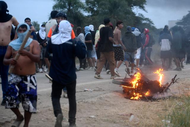 A motorcycle burns near anti-government demonstrators during clashes with police and civilians amid an operation to clear a road blockade in San Julian, Santa Cruz department, Bolivia, on June 6, 2026. Bolivia has faced days of demonstrations and road blockades amid growing political tensions and shortages affecting different regions of the country. (Photo by Rodrigo URZAGASTI / AFP)