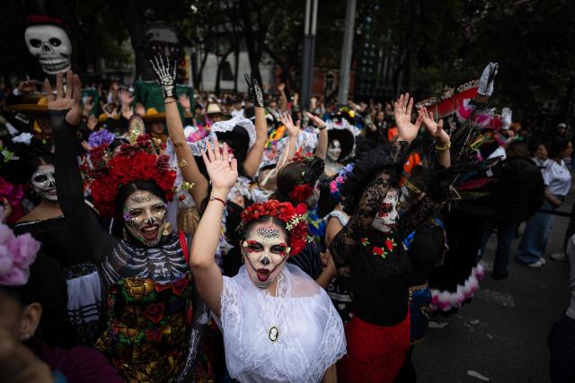 Women dressed as Catrinas wave before the start of a Guinness World Record attempt for the world’s largest Mexican Wave in Mexico City on June 6, 2026. (Photo by Carl de Souza / AFP)