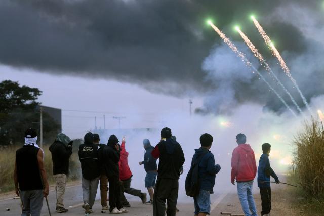 Anti-government demonstrators clash with police officers and civilians during an operation to clear a road blockade in San Julian, Santa Cruz department, Bolivia, on June 6, 2026. Bolivia has faced days of demonstrations and road blockades amid growing political tensions and shortages affecting different regions of the country. (Photo by Rodrigo URZAGASTI / AFP)