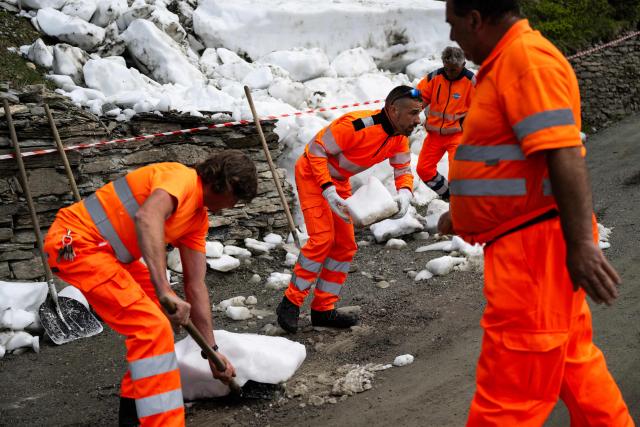 Workers remove snow from an avalanche on the road to the Colle delle Finestre during the 8th stage of the Giro d'Italia Women 2026 - Tour of Italy Women cycling race between Rivoli and Sestriere, on June 6, 2026. (Photo by MARCO BERTORELLO / AFP)