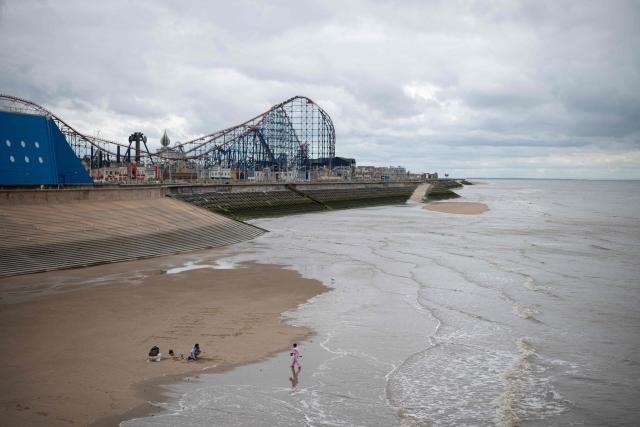 A family play on the beach near Blackpool Pleasure Beach amusement park in Blackpool, north west England on June 6, 2026. (Photo by Oli SCARFF / AFP)