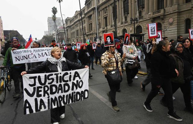 A demonstrator holds a banner reading "Justice, truth. No to impunity" during a march against the human rights policies of Chile's President Jose Antonio Kast's government in Santiago on June 6, 2026. (Photo by RODRIGO ARANGUA / AFP)