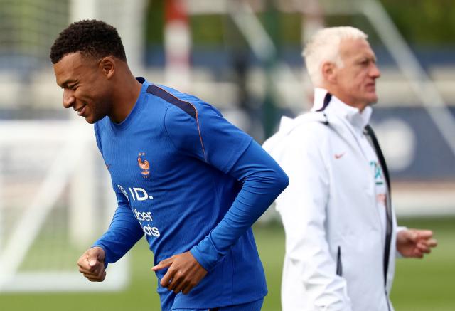 France's forward #10 Kylian Mbappe (L) reacts as he runs past France's head coach Didier Deschamps during a training session at the French Football Federation's (FFF) training ground in Clairefontaine-en-Yvelines, southwest of Paris on June 6, 2026, as part of the team's preparation for upcoming 2026 FIFA World Cup football tournament. (Photo by FRANCK FIFE / AFP)