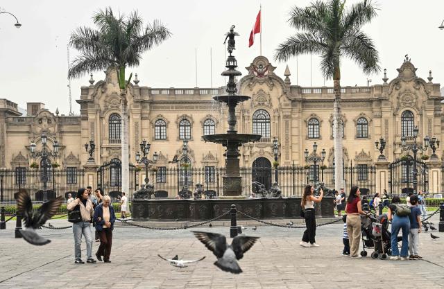 Pedestrians walk through Lima's Plaza de Armas in front of the Government Palace, in the historic center of the Peruvian capital. on June 6, 2026 ahead of the presidential runoff. Right-wing candidate Keiko Fujimori and leftist Roberto Sanchez will face off in Peru's presidential runoff on June 7, 2026. (Photo by MARTIN BERNETTI / AFP)