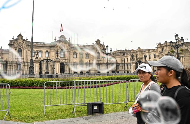Pedestrians walk through Lima's Plaza de Armas in front of the Government Palace, in the historic center of the Peruvian capital. on June 6, 2026 ahead of the presidential runoff. Right-wing candidate Keiko Fujimori and leftist Roberto Sanchez will face off in Peru's presidential runoff on June 7, 2026. (Photo by MARTIN BERNETTI / AFP)