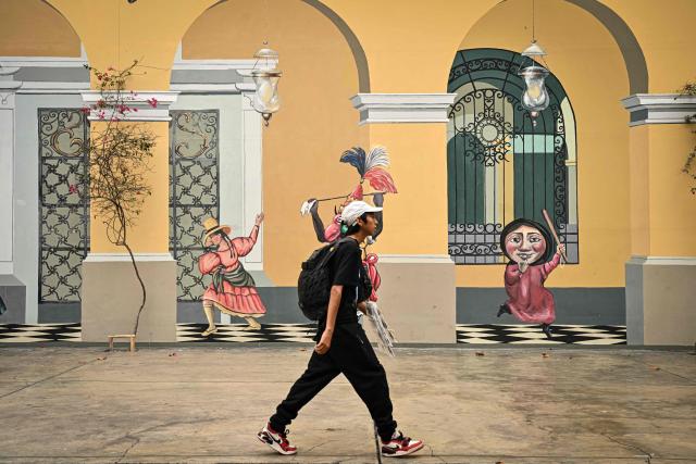 Pedestrians walk through Lima's Plaza de Armas in front of the Government Palace, in the historic center of the Peruvian capital. on June 6, 2026 ahead of the presidential runoff. Right-wing candidate Keiko Fujimori and leftist Roberto Sanchez will face off in Peru's presidential runoff on June 7, 2026. (Photo by MARTIN BERNETTI / AFP)