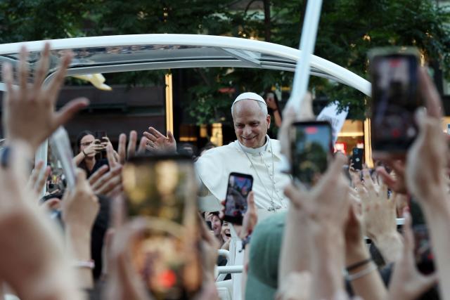 Pope Leo XIV waves to people on his way to lead a prayer vigil with young people in the Plaza de Lima in Madrid on June 6, 2026. Pope Leo XIV is visiting Spain June 6-12 with stops in Madrid, Barcelona, and the Canary Islands, where he will meet with migrants and organisations dedicated to helping them. (Photo by Pierre-Philippe MARCOU / AFP)