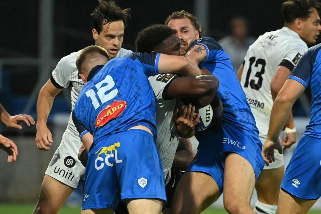 Toulon's English flanker Junior Kpoku (C) is tackled during the French Top 14 rugby union match between Castres Olympique and Rugby Club Toulonnais (Toulon)  at Stade Pierre Fabre in Castres, southern France on June 6, 2026. (Photo by Matthieu RONDEL / AFP)