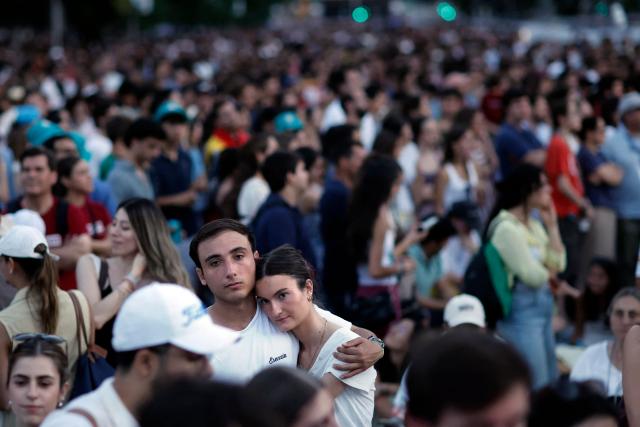 Young people attend a prayer vigil led by Pope Leo XIV in the Plaza de Lima in Madrid, with the Santiago Bernabeu stadium in the background, on June 6, 2026. Pope Leo XIV is visiting Spain June 6-12 with stops in Madrid, Barcelona, and the Canary Islands, where he will meet with migrants and organisations dedicated to helping them. (Photo by Oscar DEL POZO / AFP)
