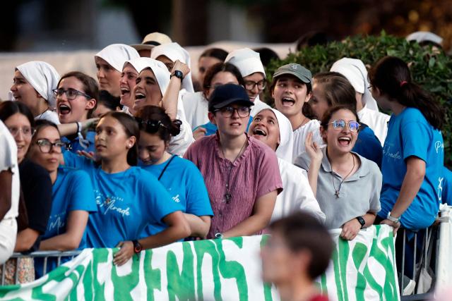 Young people attend a prayer vigil led by Pope Leo XIV in the Plaza de Lima in Madrid, with the Santiago Bernabeu stadium in the background, on June 6, 2026. Pope Leo XIV is visiting Spain June 6-12 with stops in Madrid, Barcelona, and the Canary Islands, where he will meet with migrants and organisations dedicated to helping them. (Photo by Oscar DEL POZO / AFP)