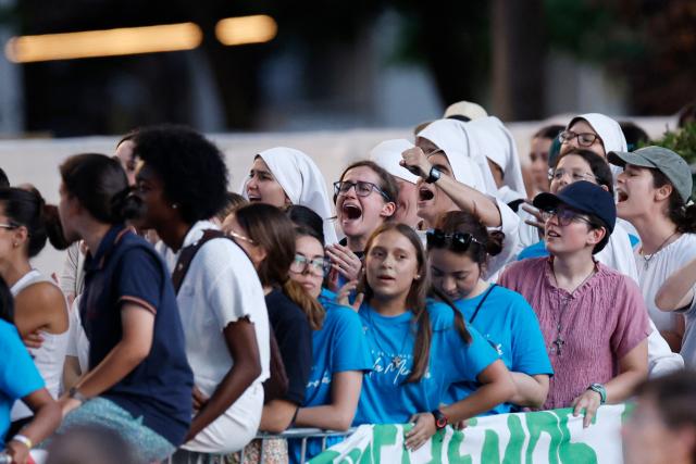 Young people attend a prayer vigil led by Pope Leo XIV in the Plaza de Lima in Madrid, with the Santiago Bernabeu stadium in the background, on June 6, 2026. Pope Leo XIV is visiting Spain June 6-12 with stops in Madrid, Barcelona, and the Canary Islands, where he will meet with migrants and organisations dedicated to helping them. (Photo by Oscar DEL POZO / AFP)