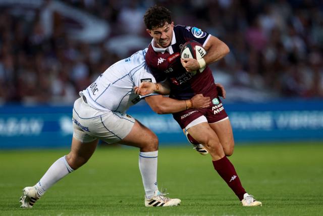 Bordeaux' French fly half Hugo Reus (R) is tackled as he runs with the ball during the French Top14 rugby union match between Union Bordeaux-Begles (UBB) and ASM Clermont Auvergne at the Chaban-Delmas Stadium in Bordeaux, south-western France on June 6, 2026. (Photo by ROMAIN PERROCHEAU / AFP)
