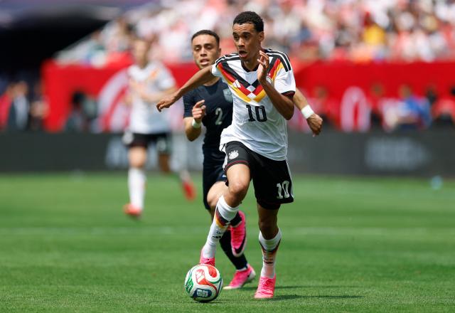 Germany's Jamal Musiala is challenged by Sergino Dest of the US during the international friendly football match between USA and Germany at Soldier Field in Chicago, Illinois on June 6, 2026. (Photo by KAMIL KRZACZYNSKI / AFP)