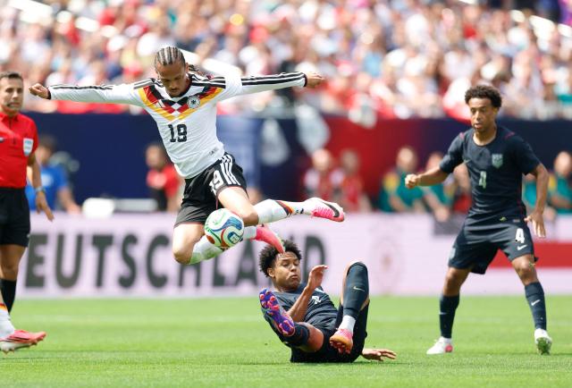 Germany's Leroy Sane jumps over Weston McKennie of the US during the international friendly football match between USA and Germany at Soldier Field in Chicago, Illinois on June 6, 2026. (Photo by KAMIL KRZACZYNSKI / AFP)