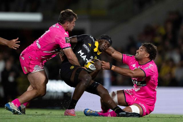 La Rochelle's French flanker Andy Timo (C) is tackled as he runs with the ball during the French Top14 rugby union match between Stade Rochelais (La Rochelle) and Stade Francais Paris at The Marcel-Deflandre Stadium in La Rochelle, western France on June 6, 2026. (Photo by XAVIER LEOTY / AFP)
