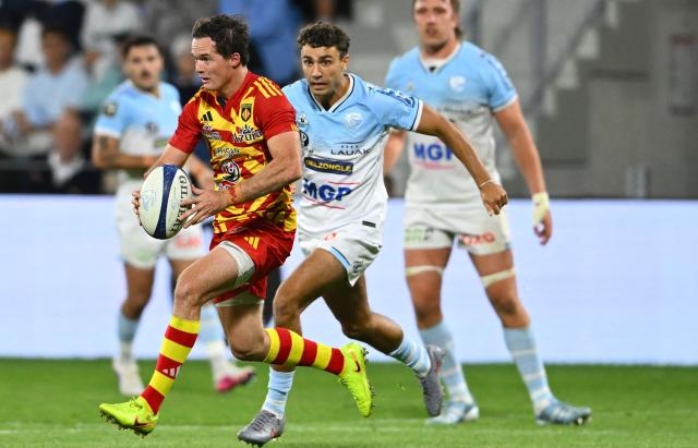 Perpignan's South-African fly-half Tristan Tedder (L) runs with the ball during the French Top14 rugby union match between Aviron Bayonnais (Bayonne) and USA Perpignan at Stade Jean Dauger in Bayonne, south-western France on June 6, 2026. (Photo by Gaizka IROZ / AFP)