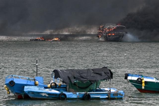 Fishing boats burn near the port of Manta, Ecuador on June 6, 2026. At least 35 fishing boats were destroyed and two people were injured in a major fire that broke out at a crowded dock in western Ecuador on June 6, 2026, according to the Risk Management Secretariat. The Ecuadorian Police stated in a press release that "the incident appears to have occurred while welding work was being carried out on a boat" and ruled out the possibility that it was an attack by criminal groups. (Photo by Ariel OCHOA / AFP)