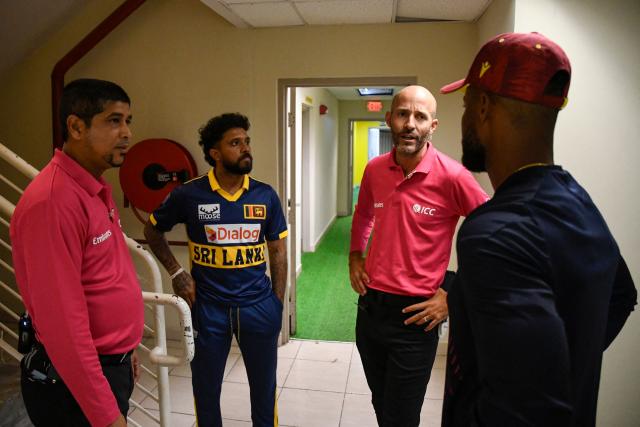 Umpires Allahuddien Paleker (L) and Christopher Taylor (3L) talk to Kusal Mendis (2L) of Sri Lanka and Shai Hope (R) of West Indies about abandoning the second One Day International (ODI) cricket match between West Indies and Sri Lanka due to the rain at Sabina Park in Kingston, Jamaica, on June 6, 2026. (Photo by Randy Brooks / AFP)