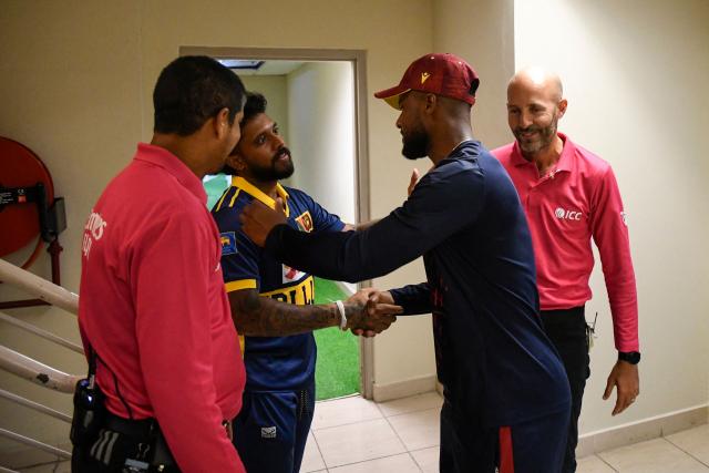 Kusal Mendis (2L) of Sri Lanka and Shai Hope (2R) of West Indies shake as they agree to the decision of umpires Allahuddien Paleker (L) and Christopher Taylor (R) to abandon the second One Day International (ODI) cricket match between West Indies and Sri Lanka due to the rain at Sabina Park in Kingston, Jamaica, on June 6, 2026. (Photo by Randy Brooks / AFP)