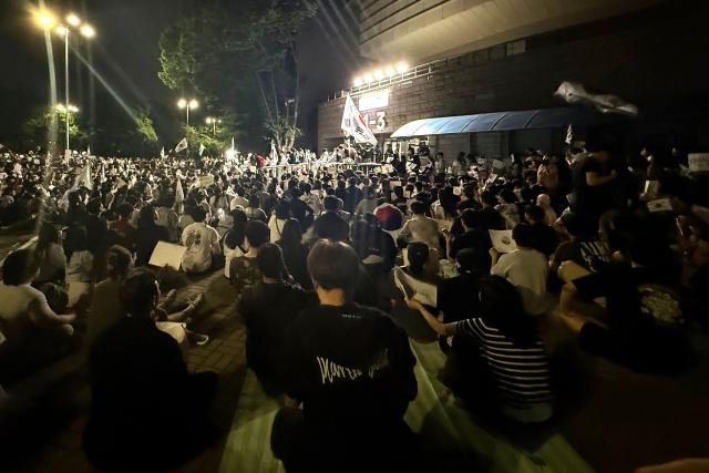 South Korean protesters demanding a rerun of the local elections due to a shortage of ballot papers stage a sit-in protest outside a ballot counting station in Seoul on June 7, 2026. Thousands of South Koreans were demanding a rerun of local elections as they protested into the wee hours of June 7, over ballot paper shortages that disrupted this week's vote. (Photo by Claire LEE / AFP)