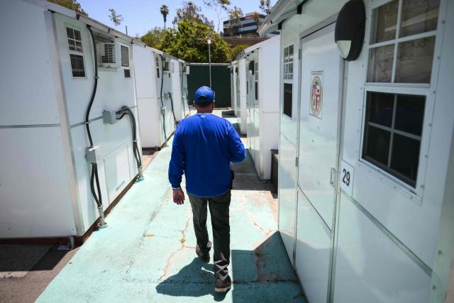 A resident walks inside a Tiny Home Village of Pallet Shelters managed by Hope The Mission in the Eagle Rock neighborhood of Los Angeles, California on June 1, 2026. Los Angeles, the second-largest US city prepares to host eight World Cup soccer matches this summer, followed by the 2028 Olympics. Infamous for its squalid encampments—located right on the sidewalks or beneath massive highway overpasses—the "City of Angels" has been pulling out all the stops over the past three years to house its homeless population. Democratic Mayor Karen Bass has made this a top priority, ramping up initiatives to fund thousands of housing spots, whether in hotels or in "tiny homes" (Photo by Patrick T. Fallon / AFP)