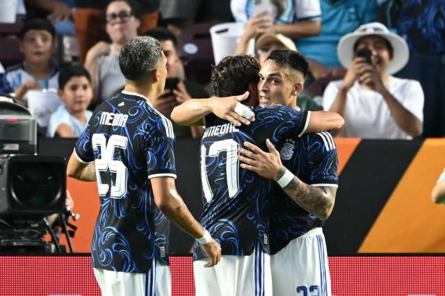 Argentina's forward #22 Lautaro Martinez (R) and Argentina's defender #25 Facundo Medina celebrate with Argentina's forward #17 Giuliano Simeone after he scored a goal during the international friendly football match between Argentina and Honduras at Kyle Field in College Station, Texas on June 6, 2026. (Photo by RONALDO SCHEMIDT / AFP)
