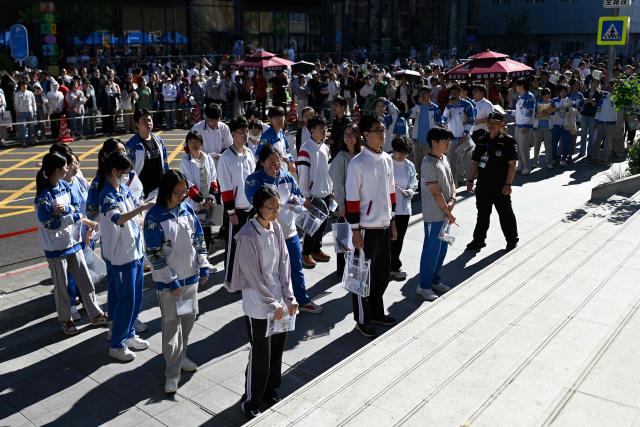 Students line up to enter a school on the first day of China's National College Entrance Examination (NCEE) known as "gaokao", in Beijing on June 7, 2026. (Photo by WANG Zhao / AFP)